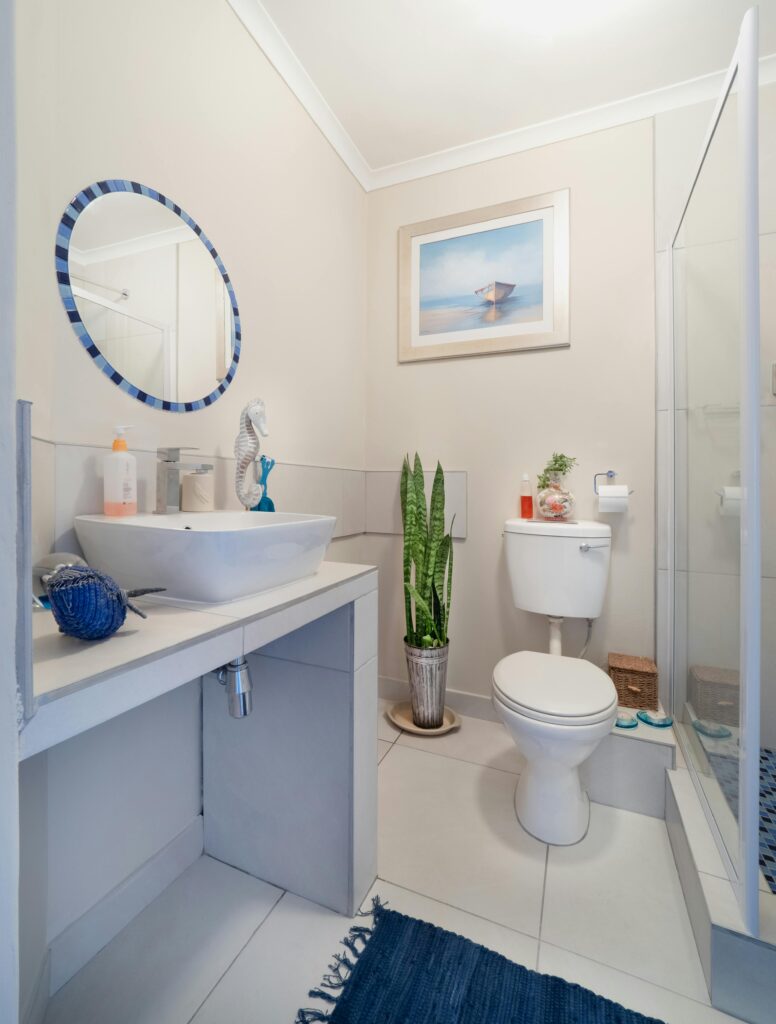 A clean, modern bathroom with white fixtures and minimalist decor, featuring a sink and toilet.