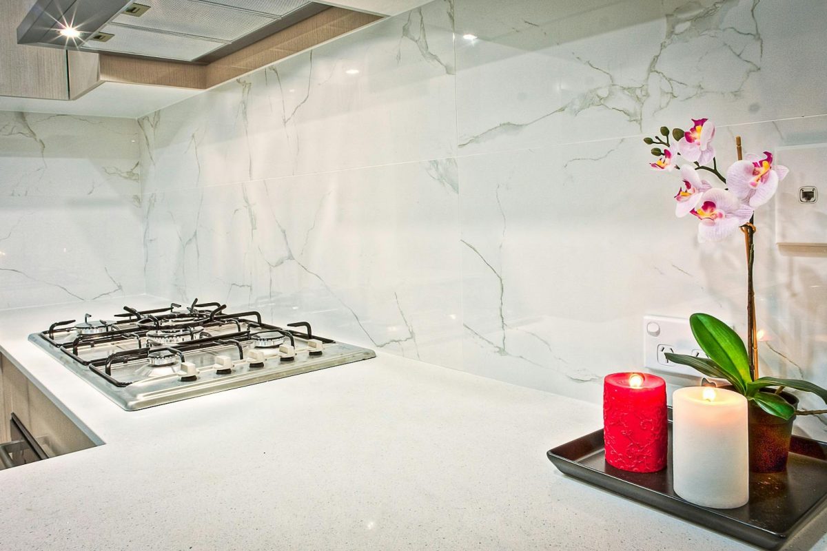 Stylish kitchen interior featuring decorative candles and orchids on a countertop.